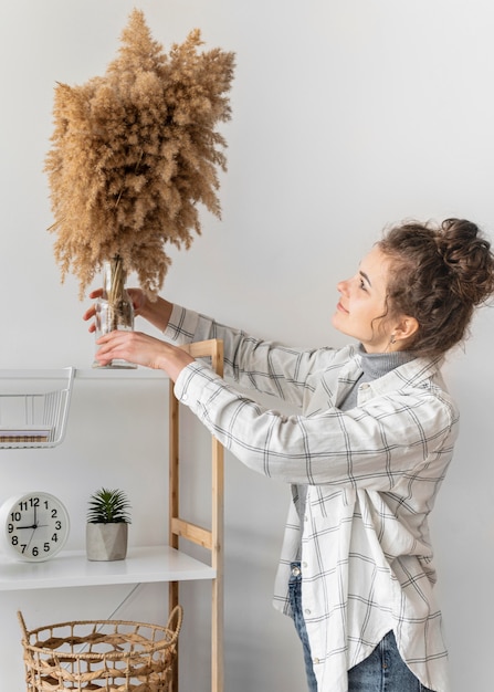 Mujer sonriente redecorando plano medio