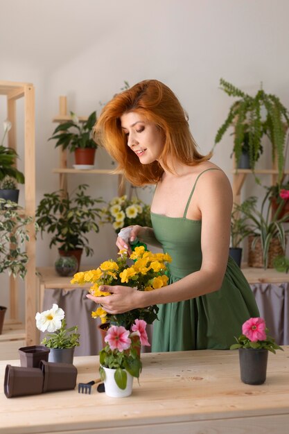 Mujer sonriente regando flor tiro medio