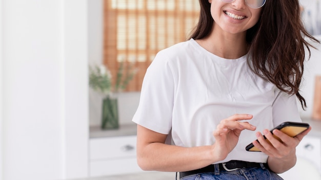 Mujer sonriente revisando su teléfono