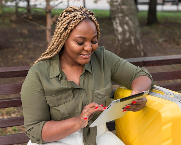 Mujer sonriente revisando sus aplicaciones de redes sociales en la tableta