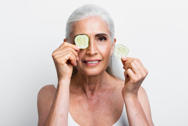 Mujer sonriente con rodajas de pepino