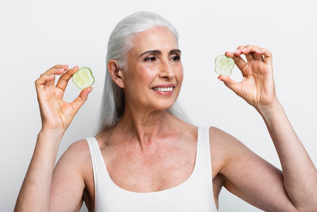 Foto gratuita mujer sonriente con rodajas de pepino