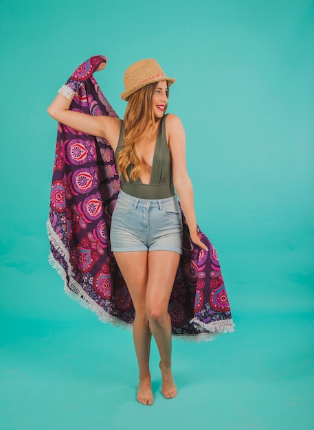 Mujer sonriente en ropa de playa con toalla