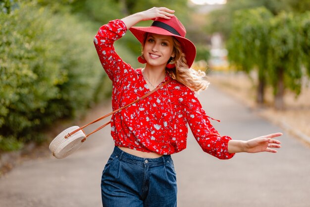 Mujer sonriente rubia elegante atractiva linda con sombrero rojo paja y traje de moda de verano blusa