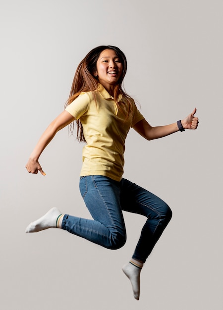 Mujer sonriente saltando en studio