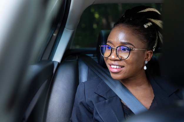 Foto gratuita mujer sonriente sentada dentro de su coche privado