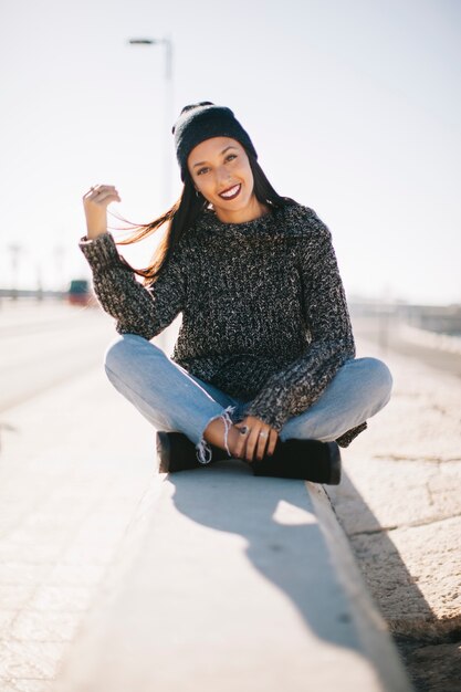 Mujer sonriente sentada en entorno urbano