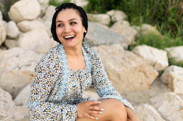 Mujer sonriente sentada en rocas