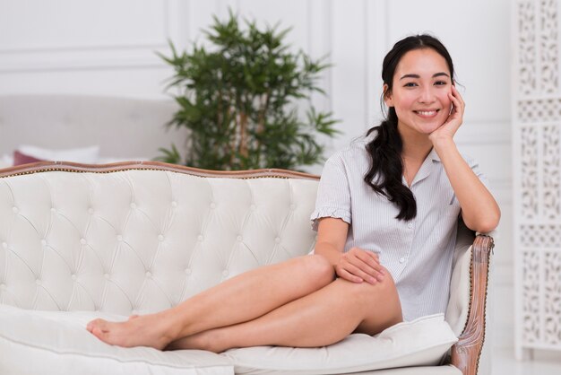 Mujer sonriente sentada en el sofá