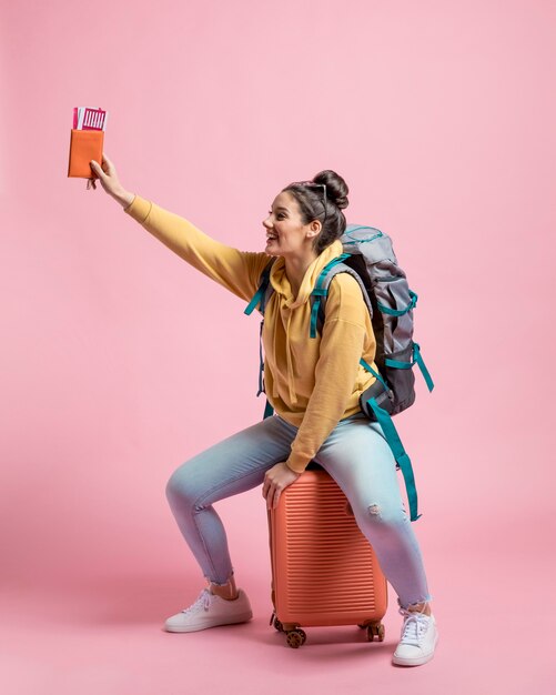 Mujer sonriente sentada en su equipaje