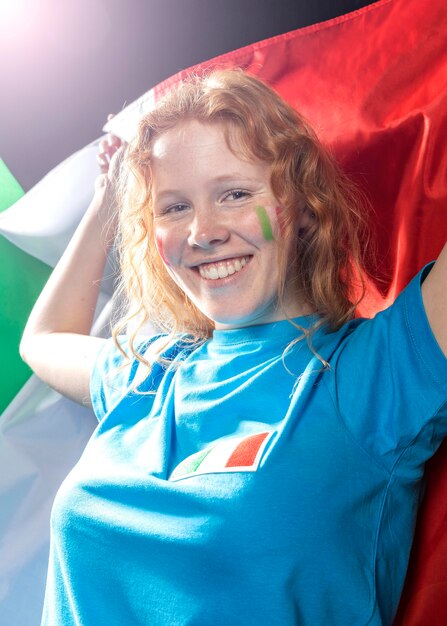 Mujer sonriente sosteniendo la bandera italiana