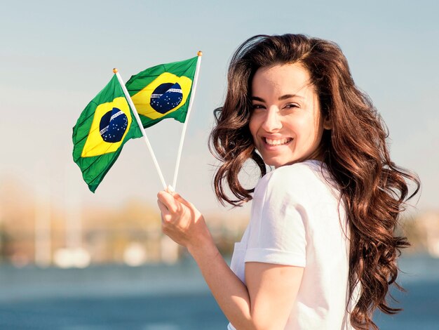 Mujer sonriente sosteniendo bandera tiro medio