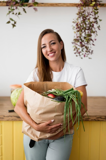 Mujer sonriente sosteniendo una bolsa de compras