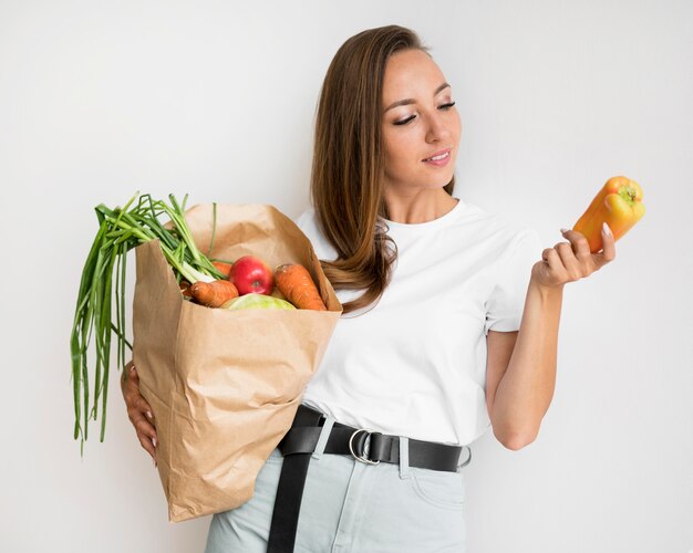 Mujer sonriente sosteniendo una bolsa de papel con comida