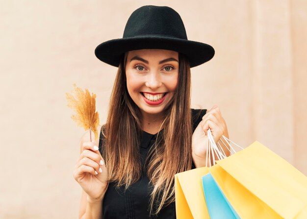 Mujer sonriente sosteniendo bolsas de la compra.