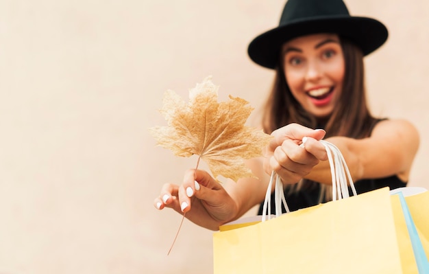 Mujer sonriente sosteniendo bolsas de la compra.