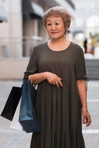 Mujer sonriente sosteniendo bolsas de la compra.
