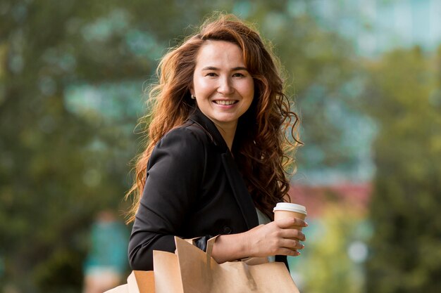 Mujer sonriente sosteniendo bolsas de la compra.