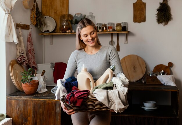 Mujer sonriente sosteniendo canasta de lavandería