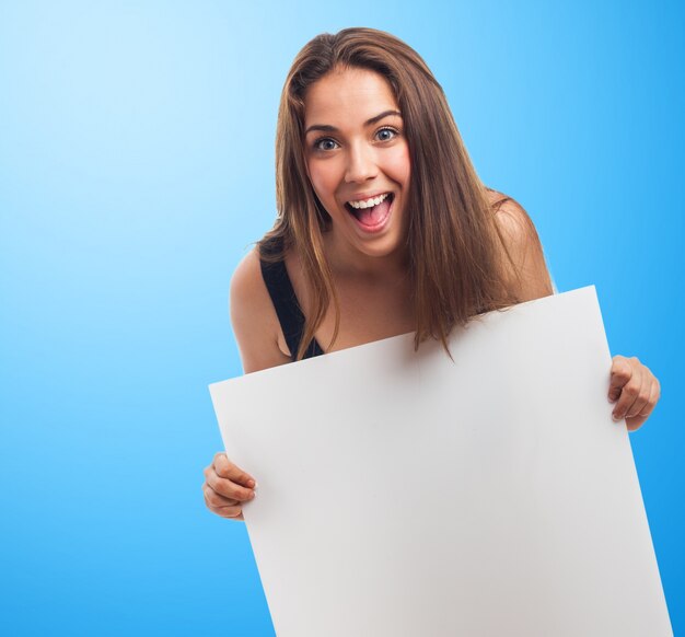 Mujer sonriente sosteniendo un cartel blanco