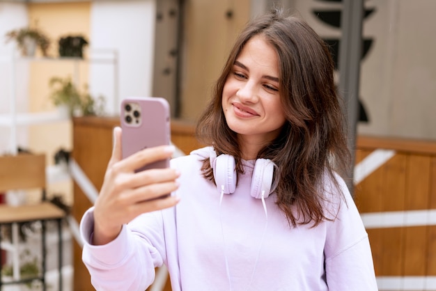 Foto gratuita mujer sonriente sosteniendo un dispositivo de tiro medio