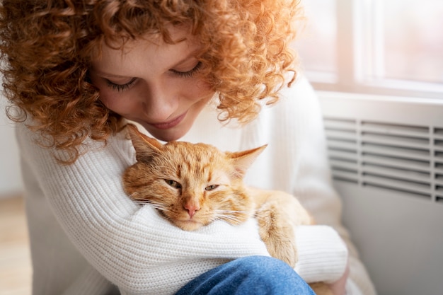 Mujer sonriente sosteniendo lindo gato