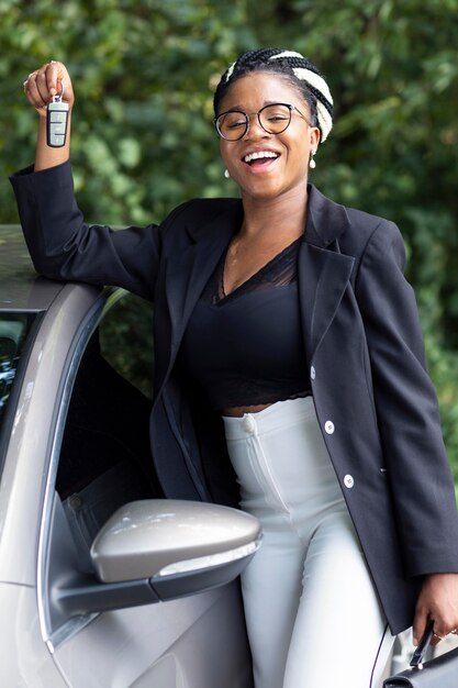 Mujer sonriente sosteniendo las llaves de su coche