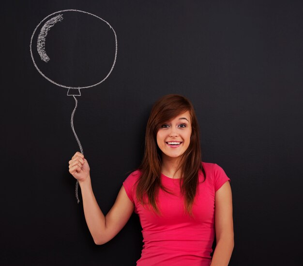 Mujer sonriente sosteniendo en la mano globo