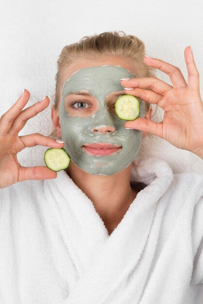 Mujer sonriente sosteniendo rodajas de pepino