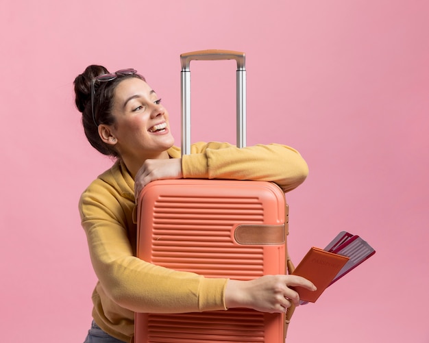 Mujer sonriente sosteniendo su equipaje