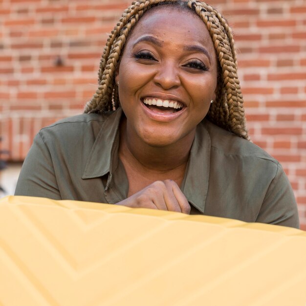 Mujer sonriente sosteniendo su equipaje