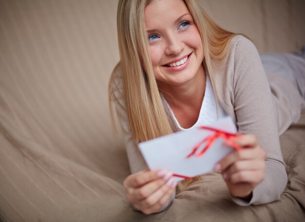 Mujer sonriente sosteniendo una tarjeta especial