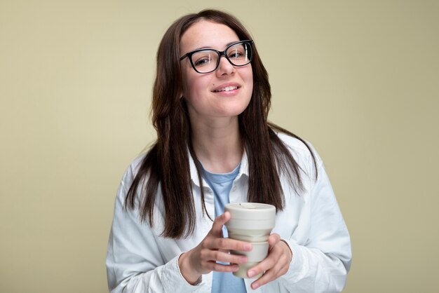 Mujer sonriente sosteniendo una taza de café de tiro medio