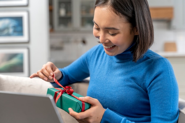 Mujer sonriente sosteniendo tiro medio de regalo