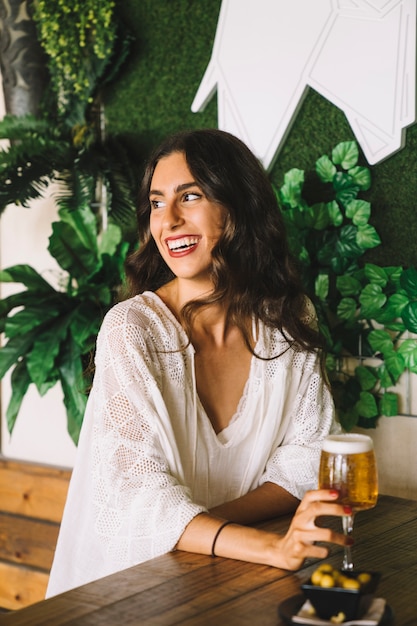 Foto gratuita mujer sonriente sujetando una cerveza