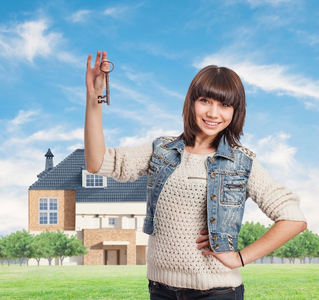 Mujer sonriente sujetando las llaves de su nuevo hogar