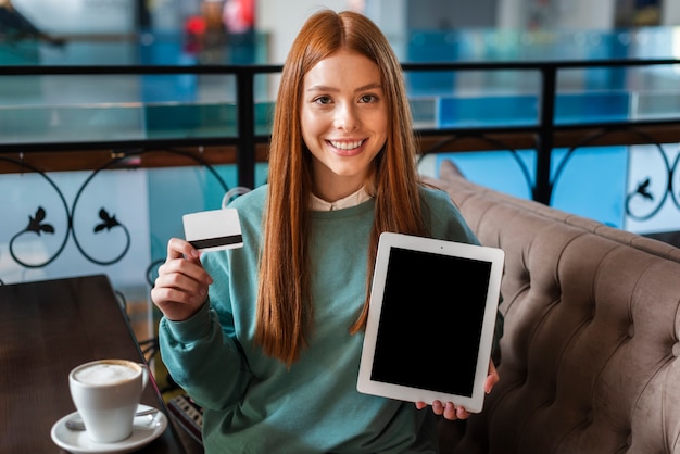 Mujer sonriente con tarjeta de crédito y foto simulacro