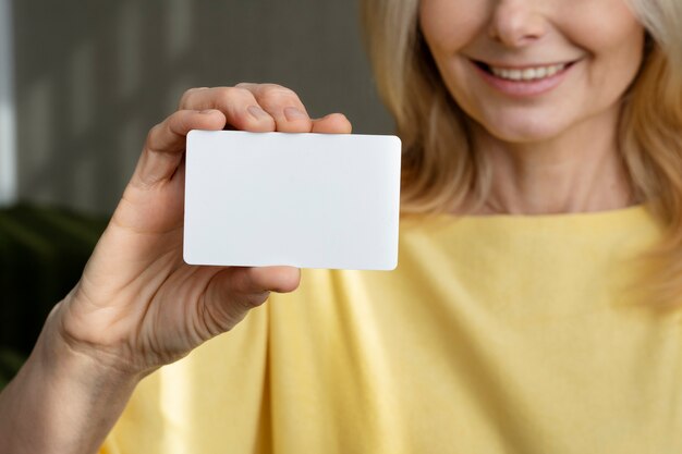 Mujer sonriente con tarjeta de visita en blanco