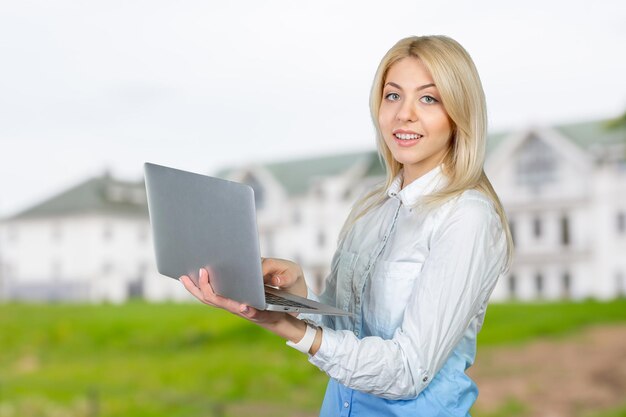 Mujer sonriente, tenencia, computador portatil