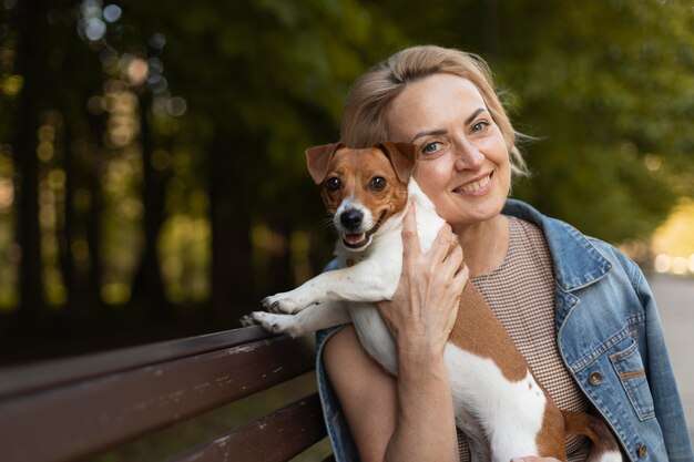 Mujer sonriente, tenencia, perro, tiro medio