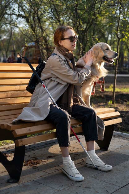 Mujer sonriente de tiro completo acariciar a perro