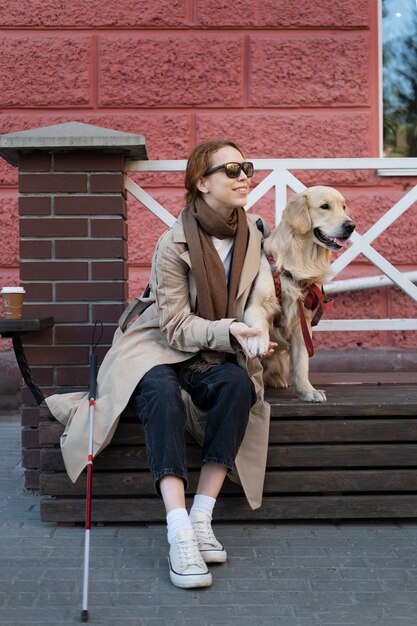 Mujer sonriente de tiro completo acariciar a perro