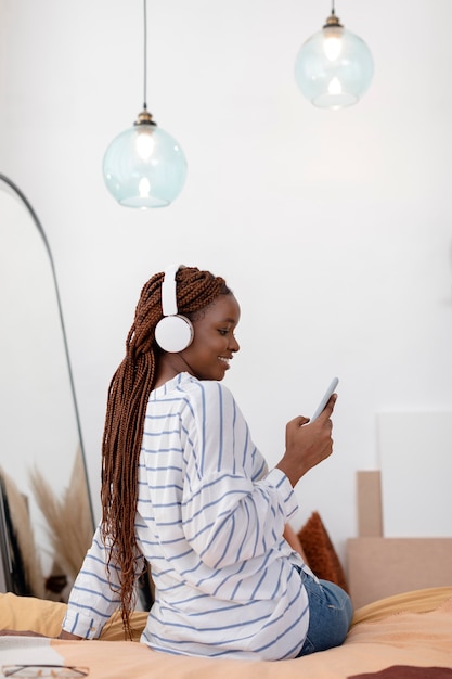 Mujer sonriente de tiro completo con auriculares