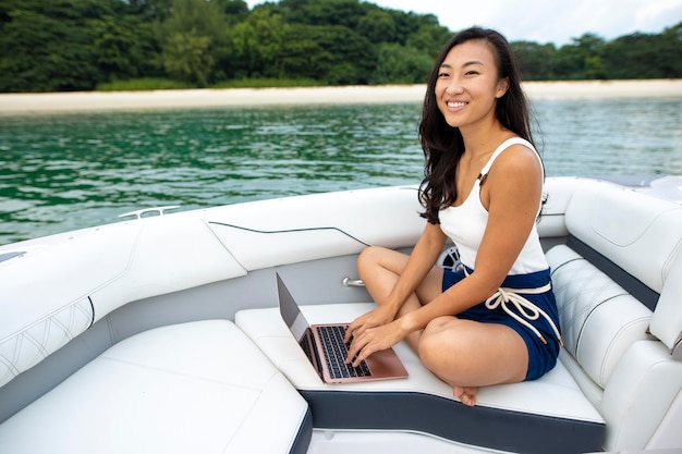 Mujer sonriente de tiro completo en barco