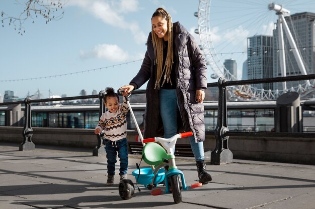 Mujer sonriente de tiro completo caminando con niño