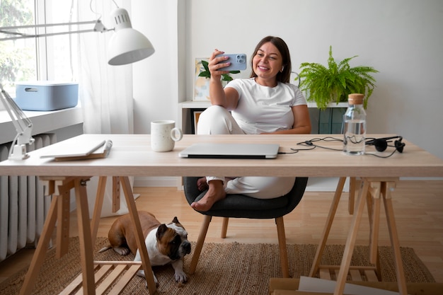 Foto gratuita mujer sonriente de tiro completo en casa