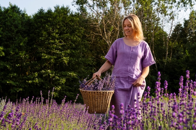 Mujer sonriente de tiro completo con cesta de lavanda