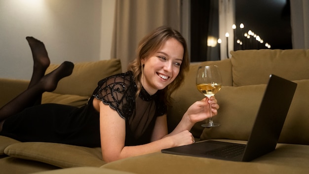 Mujer sonriente de tiro completo con copa de vino