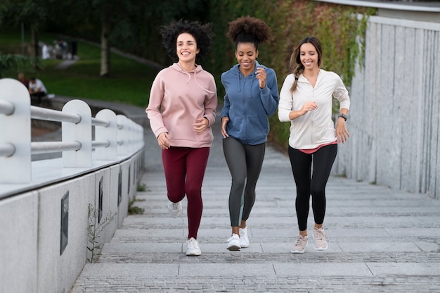 Foto gratuita mujer sonriente de tiro completo corriendo en las escaleras