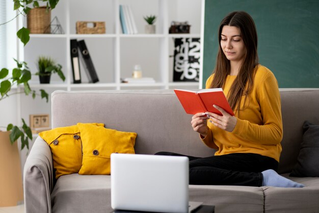 Mujer sonriente de tiro completo con cuaderno